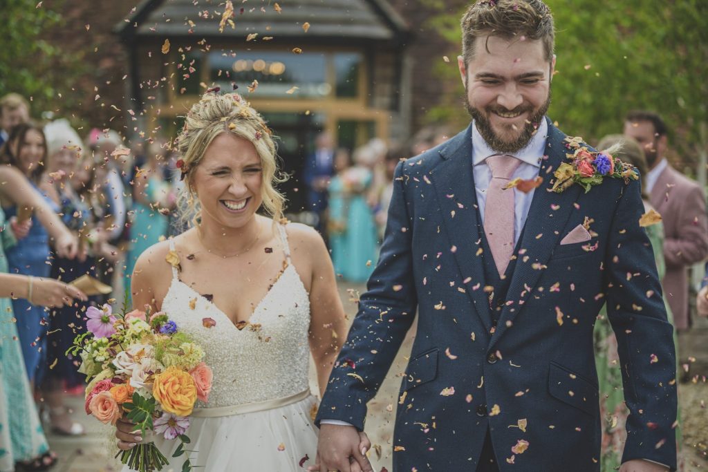 An awesome documentary style wedding photo of a couple surrounded by confetti!